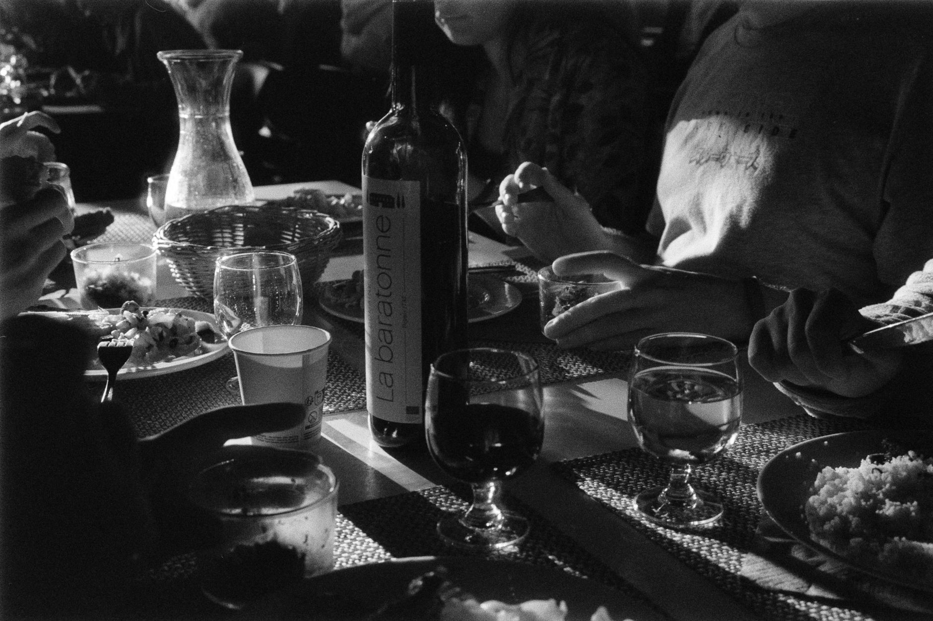 black and white photo of people sitting at a table and dining